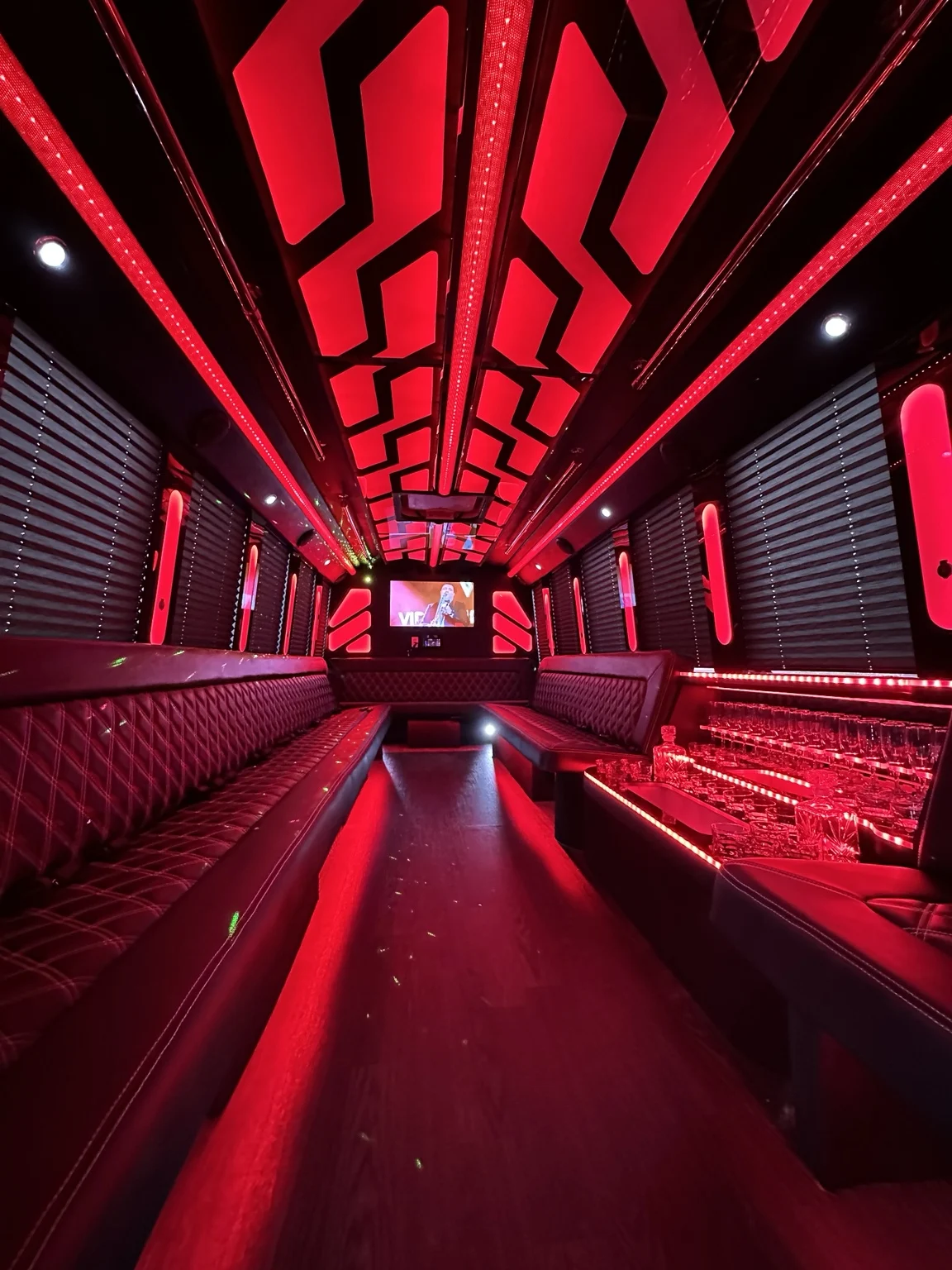 Party bus interior with red accent lighting and lounge seating