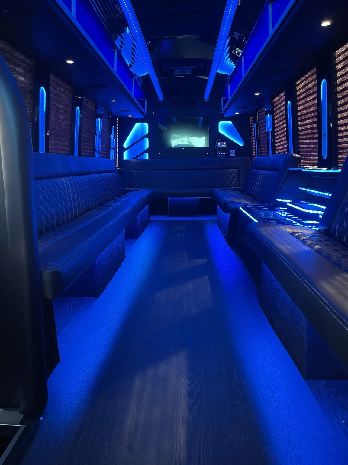 Party bus lounge with blue lighting and quilted seating