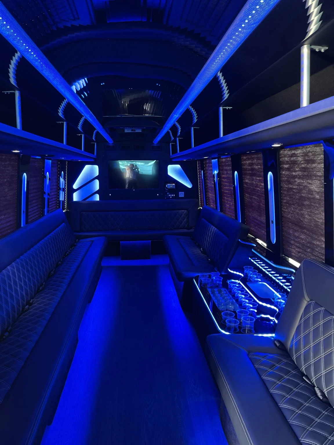 Blue illuminated party bus lounge and glassware display