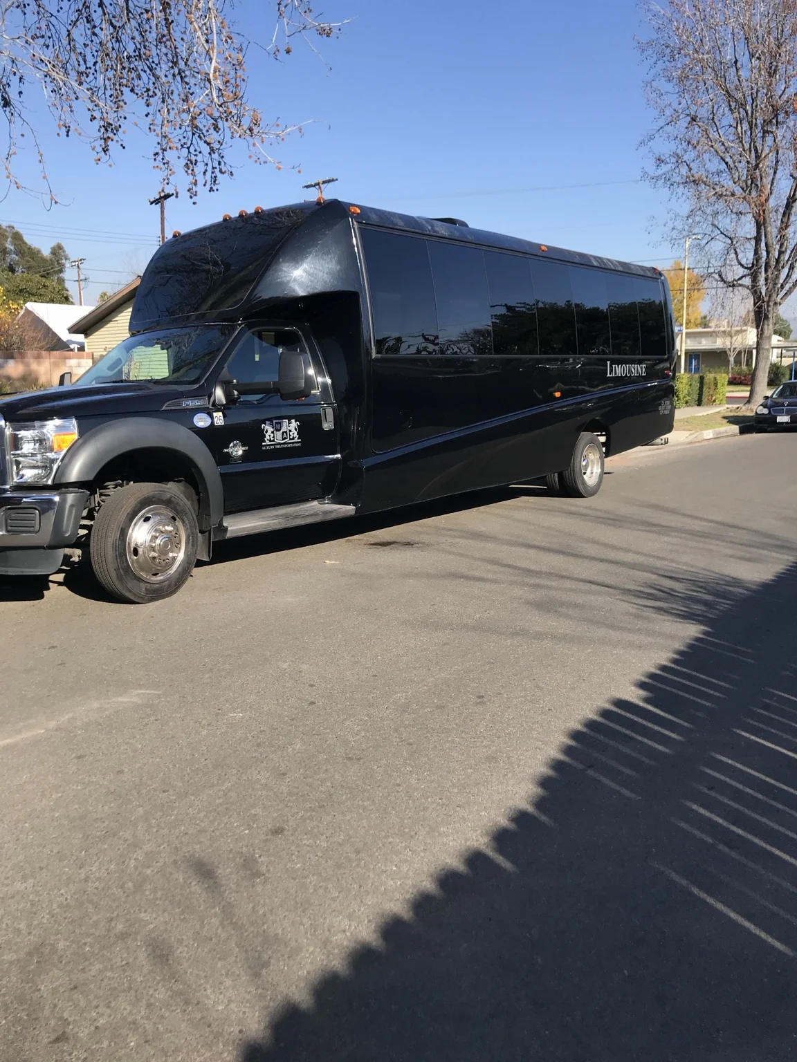 Black Ford limousine bus parked outdoors