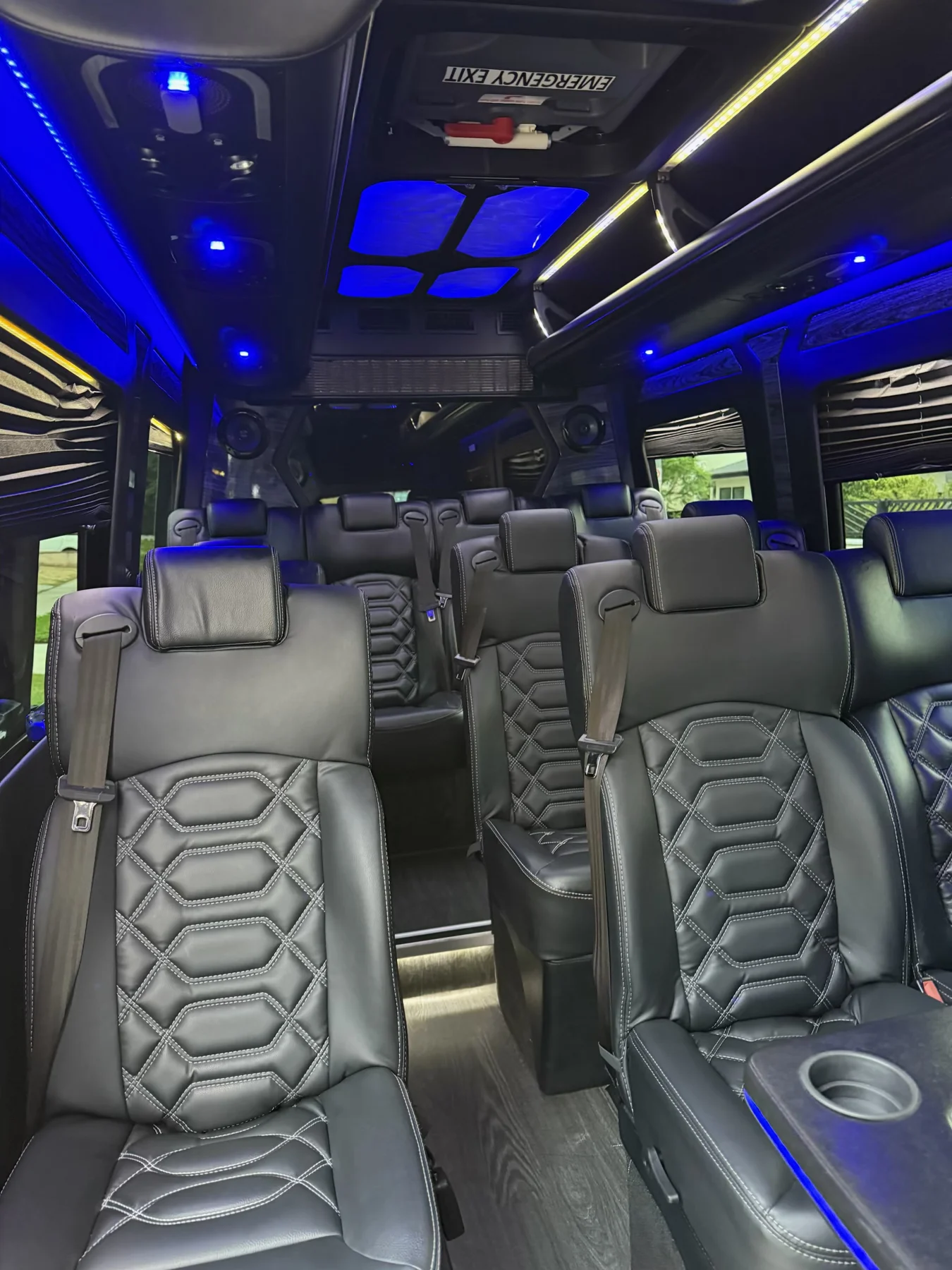 Luxury passenger cabin with individual black leather seats and blue ceiling lighting