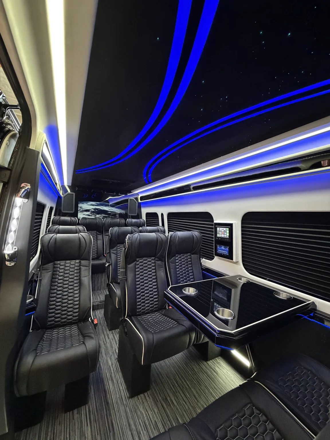Vehicle interior with black seats and blue ceiling lights