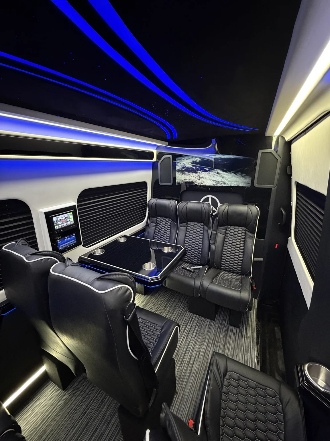 Vehicle cabin with black seating and illuminated ceiling
